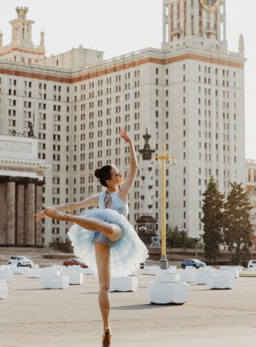 ballerina dancing near white concrete building during daytime