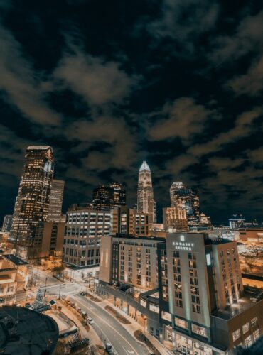 city buildings under dark clouds during night time