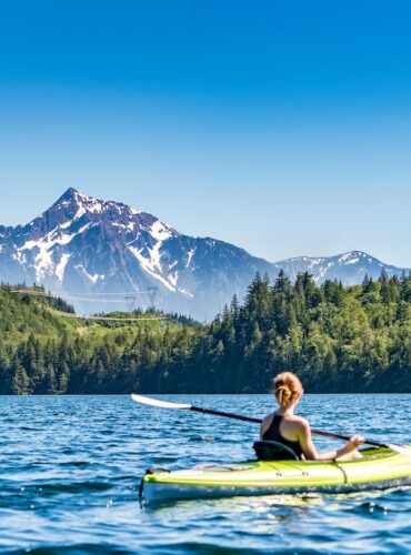 woman kayaking on lake during daytime