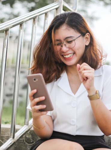woman in white button up shirt holding silver iphone 6