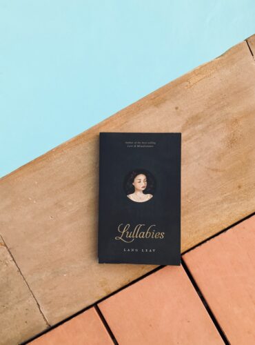 a book sitting on top of a wooden floor next to a pool