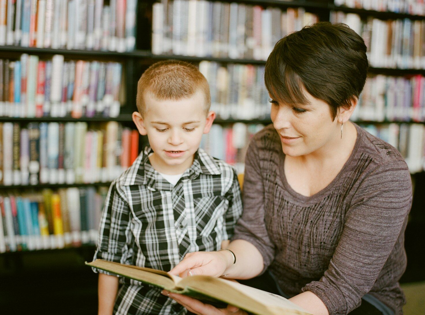 boy in gray sweater beside boy in gray and white plaid dress shirt